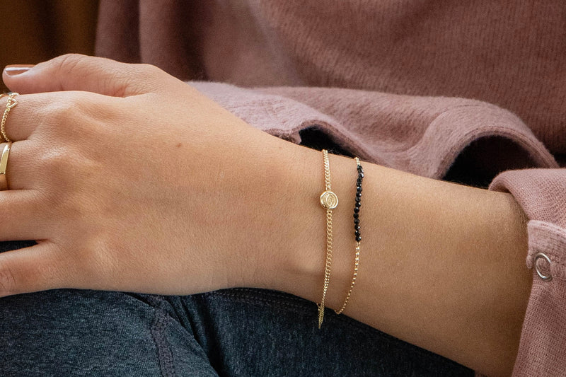 צמיד זהב עדין עם אבנים שחורות 